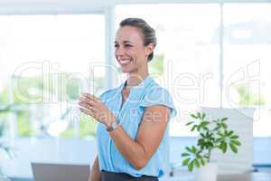 Smiling businesswoman holding disposable cup