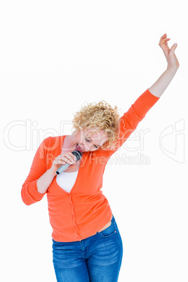 Happy pretty blonde singing in microphone