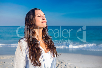 Happy woman with eyes closed at the beach