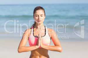 Fit woman doing yoga beside the sea