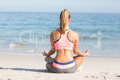 Fit woman doing yoga beside the sea