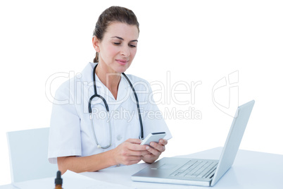 Doctor working on her laptop and her phone