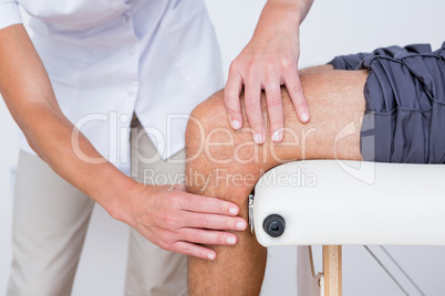 Doctor examining her patient knee