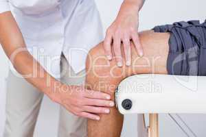 Doctor examining her patient knee