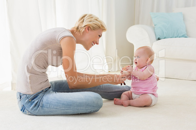 Happy mother playing with her baby girl