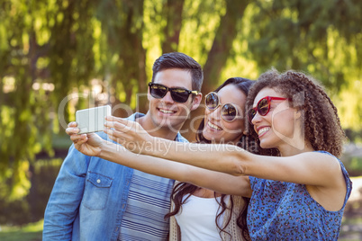 Happy friends taking a selfie in the park