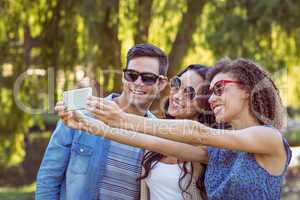 Happy friends taking a selfie in the park