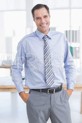 Businessman smiling at camera with hands on his pocket