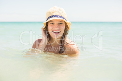 Happy pretty blonde bathing into the sea with hat