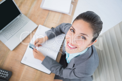 Smiling businesswoman looking at camera with credit card