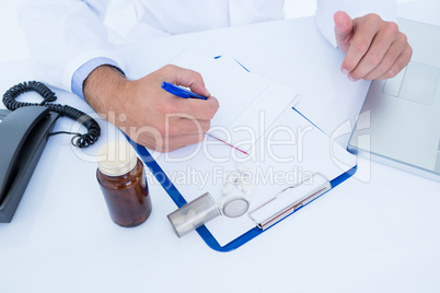 Doctor writing down on a notebook