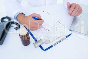 Doctor writing down on a notebook