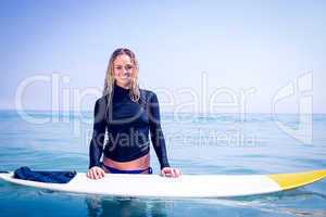 Woman with a surfboard smiling at camera