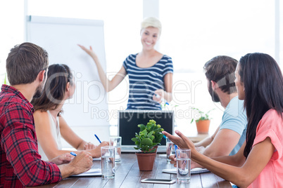 Casual businesswoman giving presentation to her colleagues