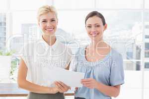 Smiling businesswomen looking at camera and working together