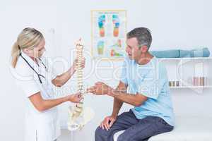 Doctor showing anatomical spine to her patient