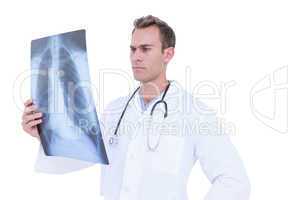 Serious young doctor looking at x-ray