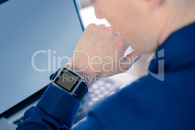 Rear view of businessman watching his smartwatch