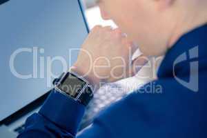 Rear view of businessman watching his smartwatch