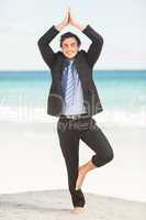 Happy businessman doing yoga