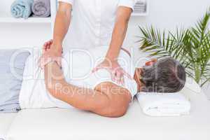 Physiotherapist doing shoulder massage to her patient
