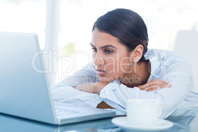 Tired businesswoman looking at her laptop