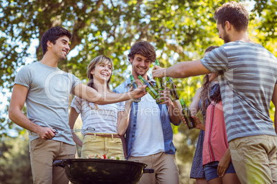 Happy friends in the park having barbecue