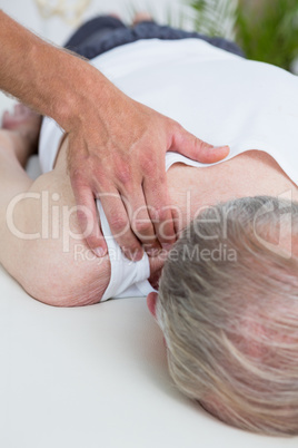 Physiotherapist doing shoulder massage to his patient