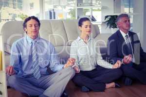 Business people meditating in lotus pose
