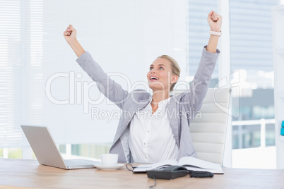 Happy businesswoman with raised arms