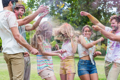 Happy friends throwing powder paint