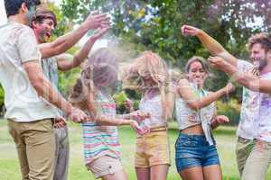 Happy friends throwing powder paint