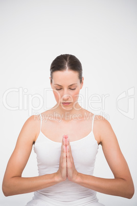 Fit woman meditating with hands crossed