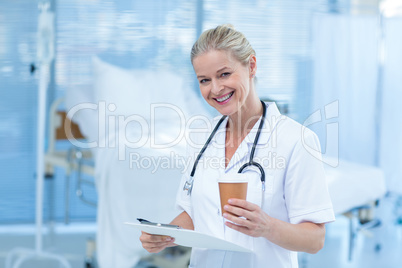 Beautiful smiling doctor holding clipboard and goblet