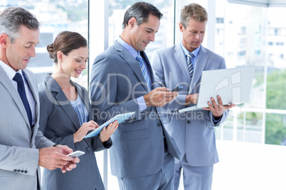 Business colleagues using their multimedia devices