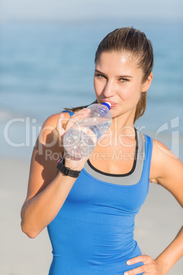 Portrait of beautiful fit woman drinking water