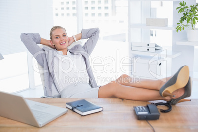 Smiling businesswoman relaxing on her office