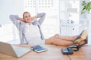 Smiling businesswoman relaxing on her office