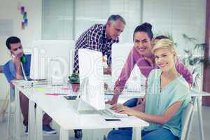 Smiling photo editors using computer in office
