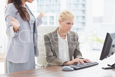 Businesswoman giving orders at her coworker