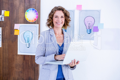 Creative businesswoman holding laptop computer Creative businesswoman holding laptop computer