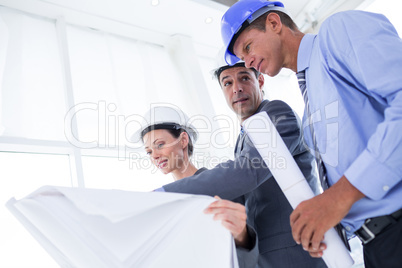 Businessman explaining a blueprint to his colleagues