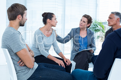 Concerned woman comforting another in rehab group