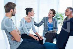 Concerned woman comforting another in rehab group