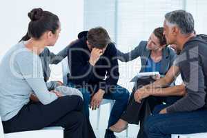 Concerned patients comforting another in rehab group