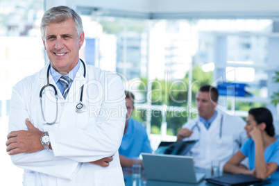 Smiling doctor looking at camera with arms crossed