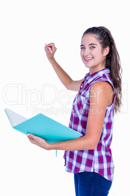 Pretty brunette writing and holding notebook