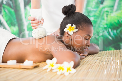 Pretty woman enjoying a herbal compress massage