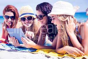Happy friends wearing sunglasses and using tablet