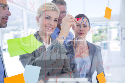 Businesswoman drawing graph on the board